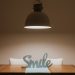 Stylish interior featuring a wooden table, modern lamp, and 'Smile' decor for a warm ambiance.